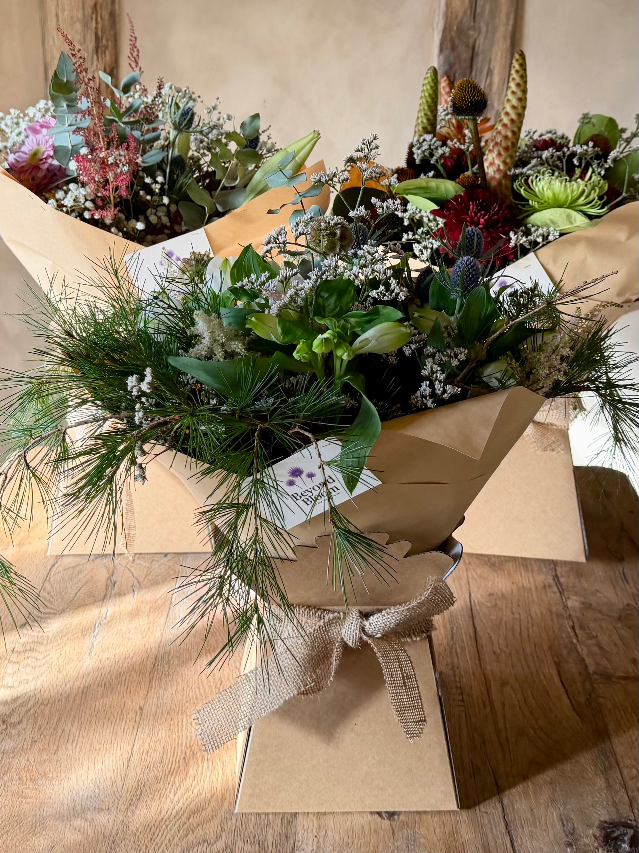 Bouquet of flowers wrapped in brown paper on a wooden surface