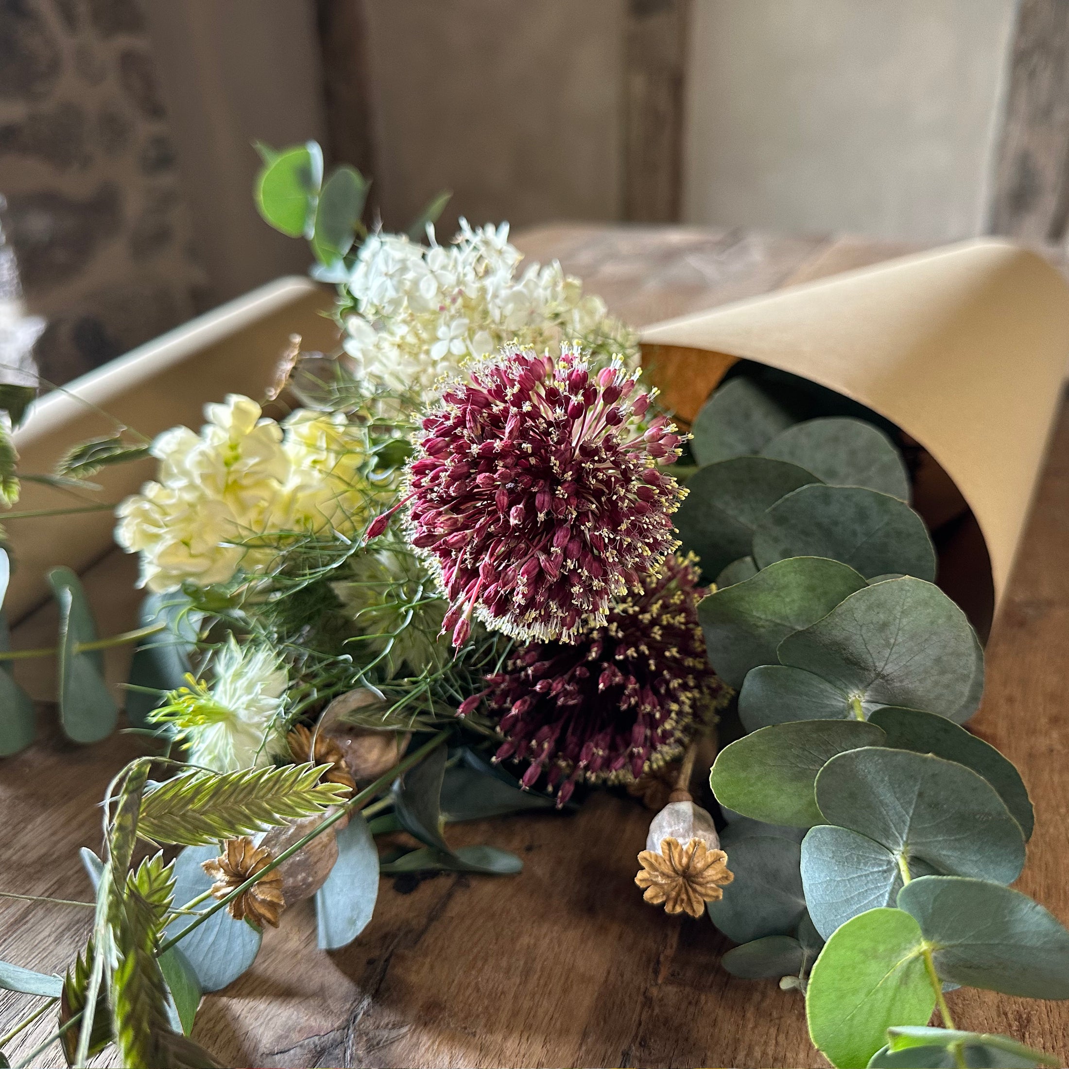 Bouquet of flowers with greenery on a wooden surface