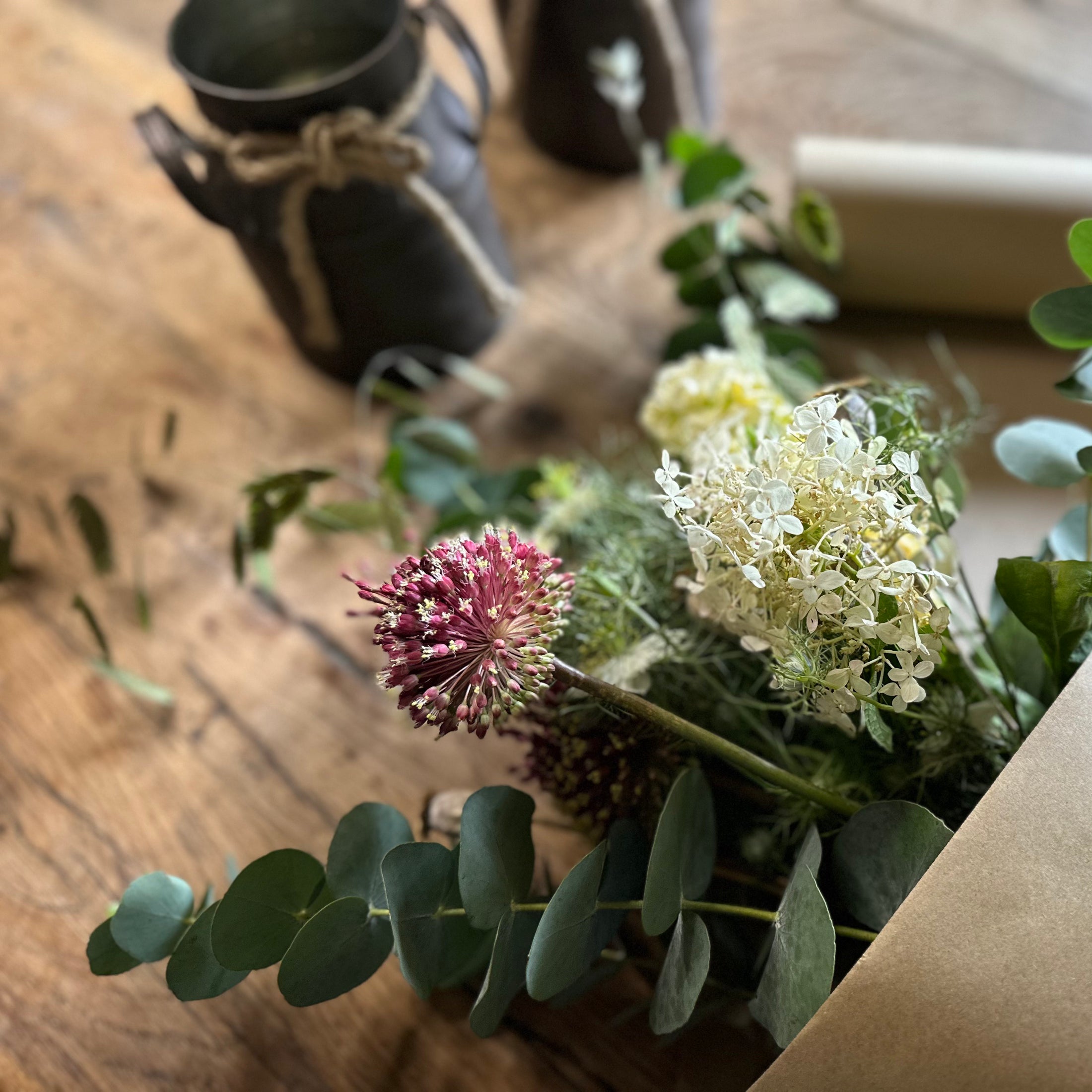 Bouquet of flowers with green leaves on a wooden surface